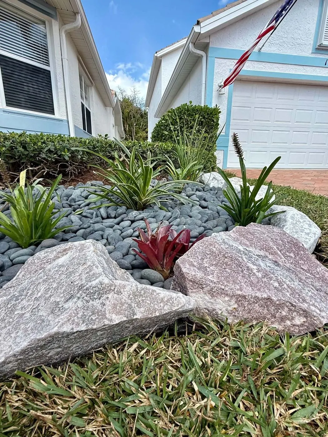 River-rock front bed with boulders and bromeliads